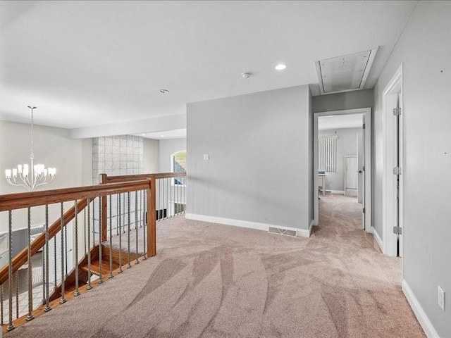 hallway featuring light carpet and an inviting chandelier