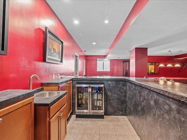 bar featuring hanging light fixtures, light tile patterned flooring, beverage cooler, and sink