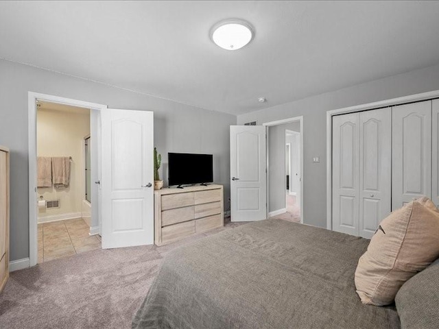 bedroom featuring connected bathroom, light colored carpet, and a closet