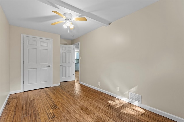 unfurnished bedroom featuring beamed ceiling, ceiling fan, and hardwood / wood-style flooring