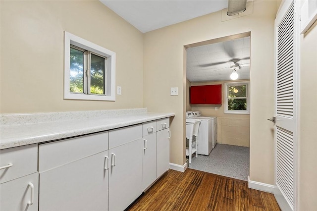 washroom with ceiling fan, dark hardwood / wood-style flooring, washer and dryer, and cabinets