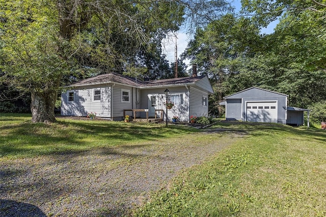 ranch-style home with a garage, an outbuilding, and a front yard