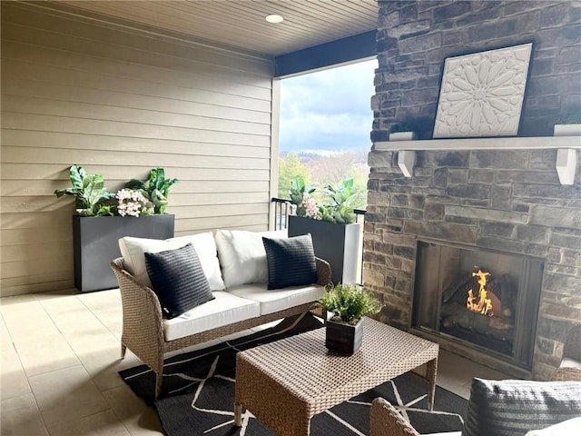 balcony featuring an outdoor living space with a fireplace and a patio area