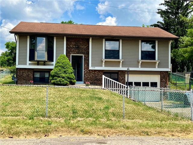 split foyer home with a garage and a front yard