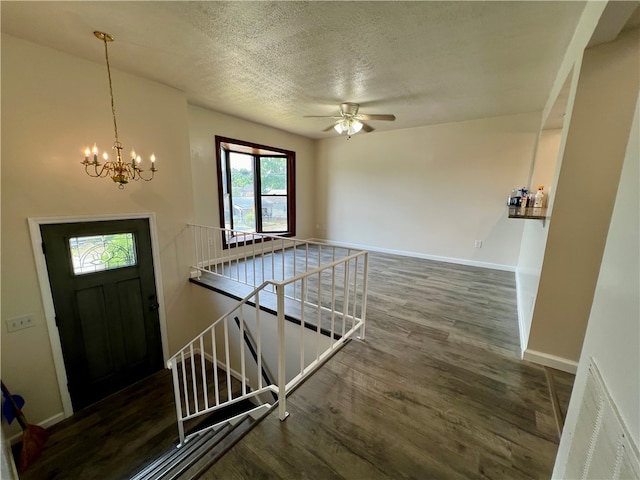 foyer featuring ceiling fan with notable chandelier, hardwood / wood-style floors, and a textured ceiling