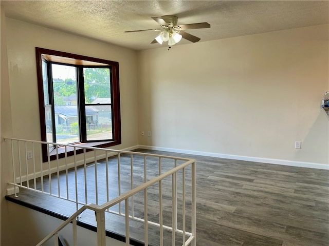 spare room with hardwood / wood-style flooring, a textured ceiling, and ceiling fan