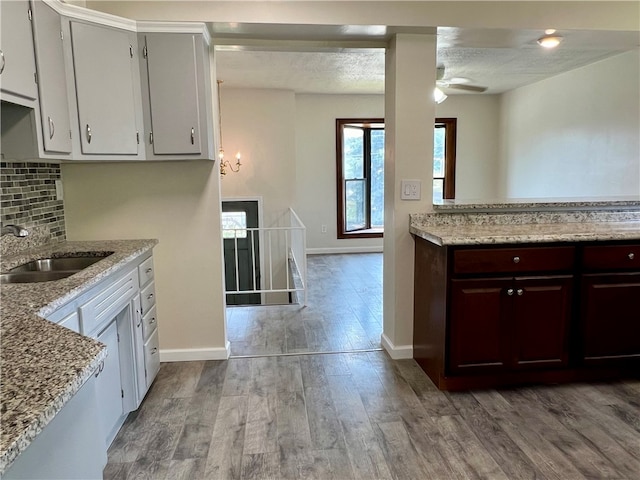 kitchen featuring backsplash, a textured ceiling, ceiling fan, and hardwood / wood-style floors