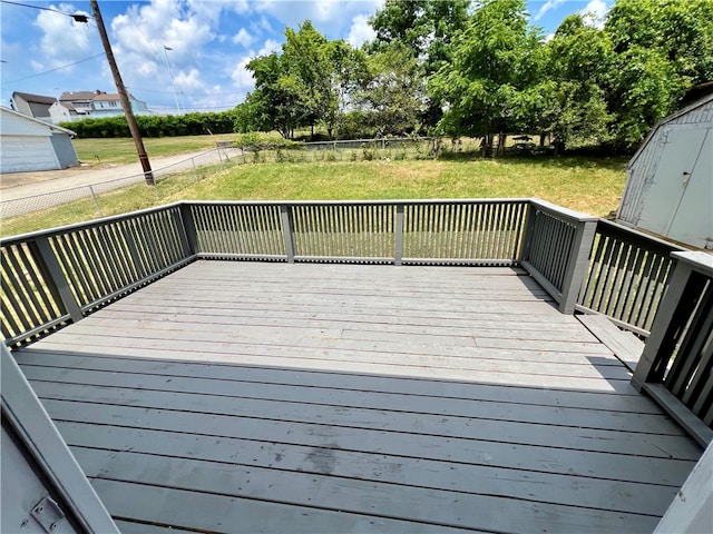 wooden deck featuring an outdoor structure and a yard