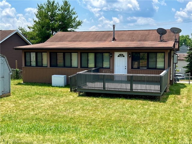 back of house featuring a wooden deck and a lawn