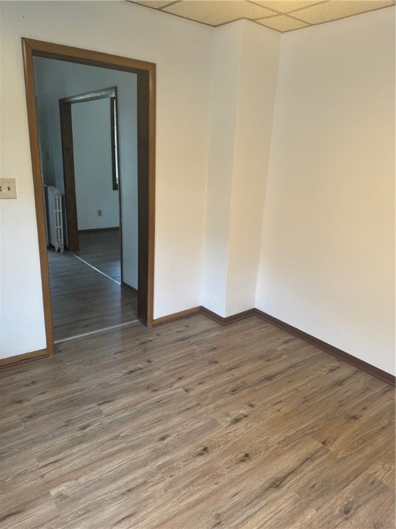 unfurnished room with radiator heating unit and hardwood / wood-style flooring