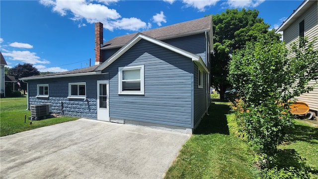 view of front of house with a front lawn and central AC unit