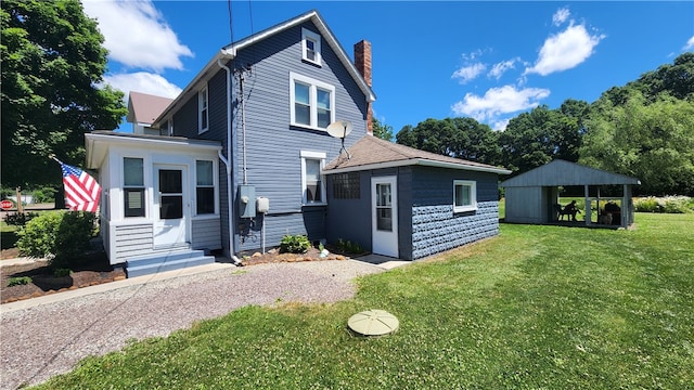 rear view of property with a lawn and a storage shed