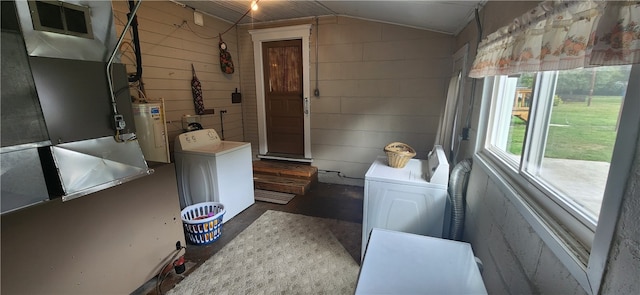 bathroom featuring lofted ceiling, heating unit, wooden walls, washer / clothes dryer, and water heater