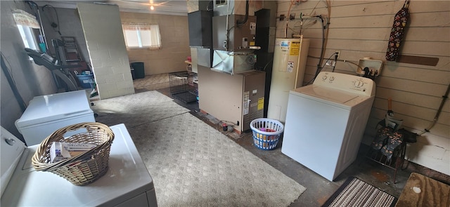 laundry room featuring heating unit, water heater, and separate washer and dryer