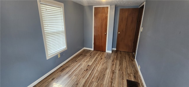 interior space featuring a textured ceiling and hardwood / wood-style floors