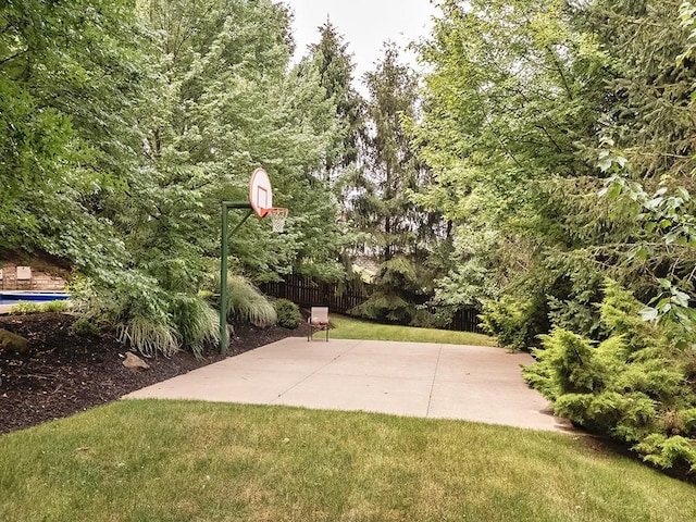 view of sport court featuring a lawn