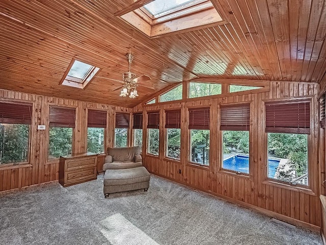 unfurnished sunroom with vaulted ceiling with skylight, ceiling fan, and wooden ceiling