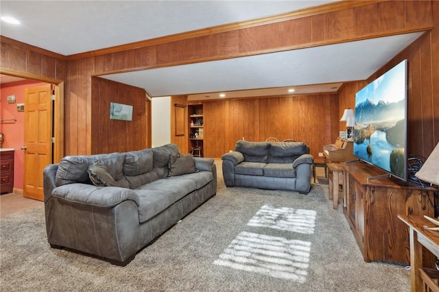 carpeted living room featuring wood walls