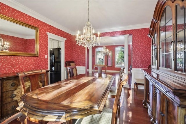 dining space with ornate columns, crown molding, dark hardwood / wood-style floors, and an inviting chandelier