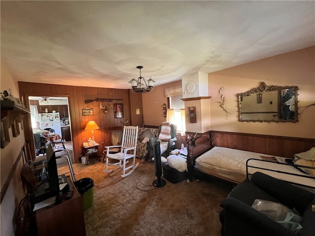 living room with a chandelier, carpet flooring, and wooden walls