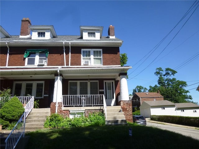 view of front of house with a porch, stairway, and a chimney