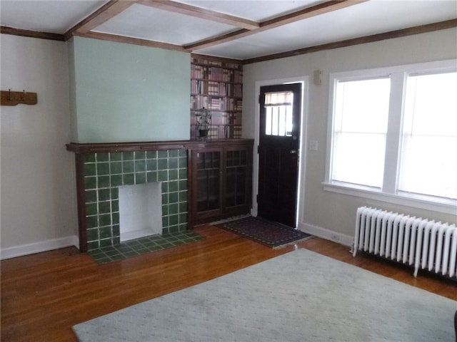 unfurnished living room featuring wood-type flooring and radiator