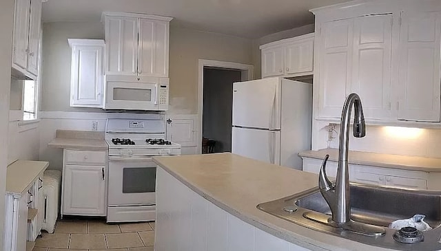 kitchen with light tile patterned floors, white appliances, a sink, white cabinets, and light countertops