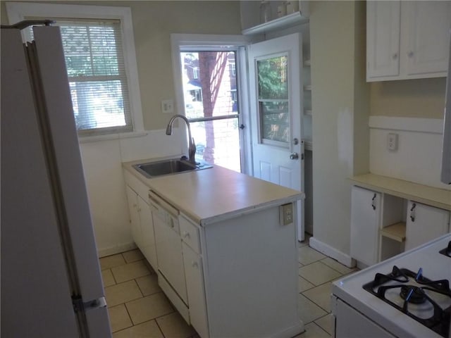 kitchen with light countertops, white cabinetry, a sink, white appliances, and a peninsula