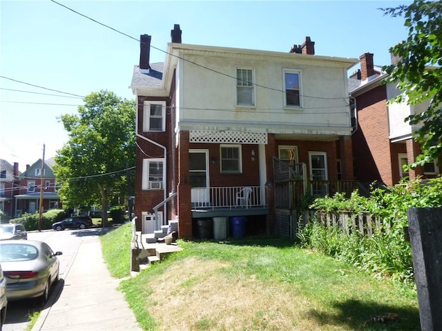 view of front facade with covered porch, brick siding, a chimney, and stucco siding