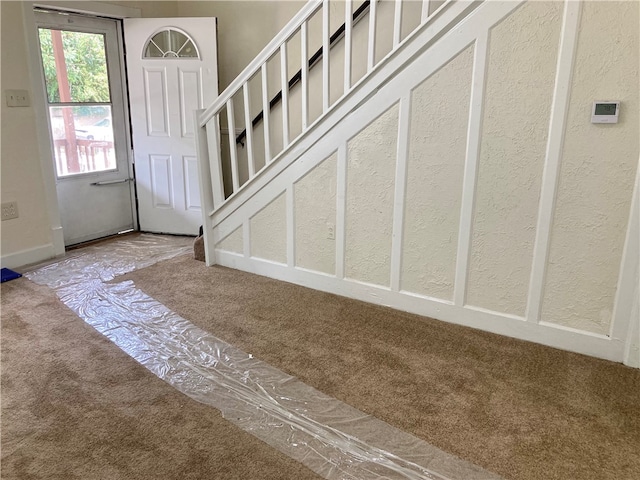 staircase featuring carpet