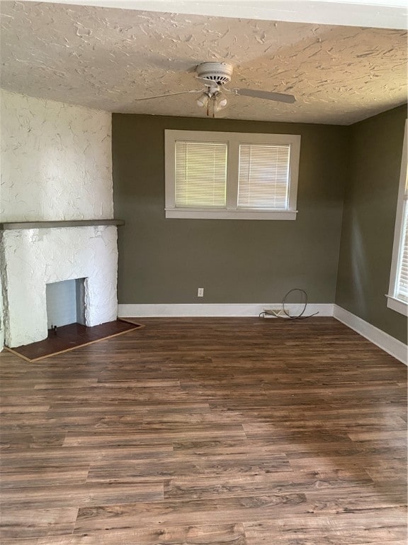 unfurnished living room with a fireplace, a textured ceiling, ceiling fan, and wood-type flooring