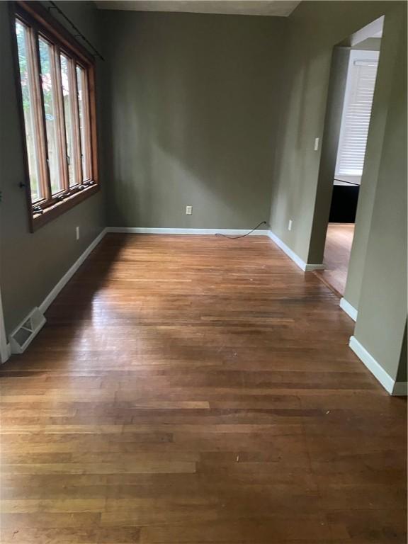 unfurnished room with dark wood-type flooring