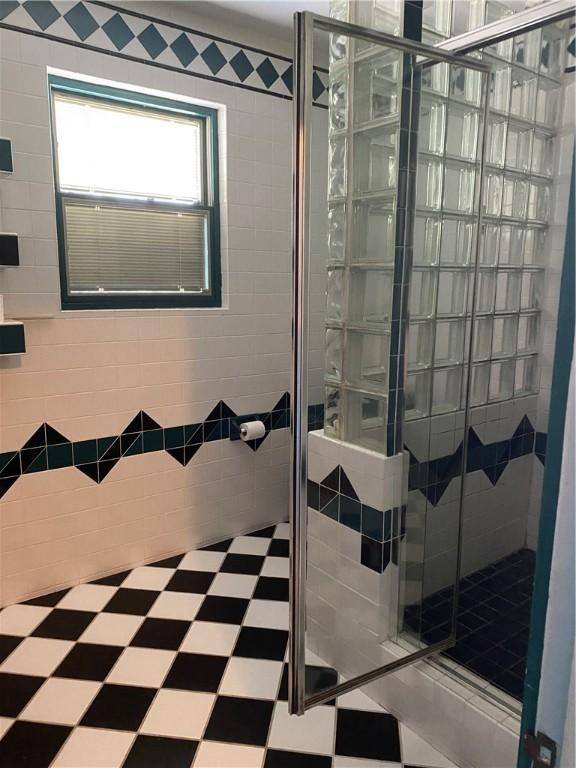 bathroom featuring a shower with door and tile patterned flooring