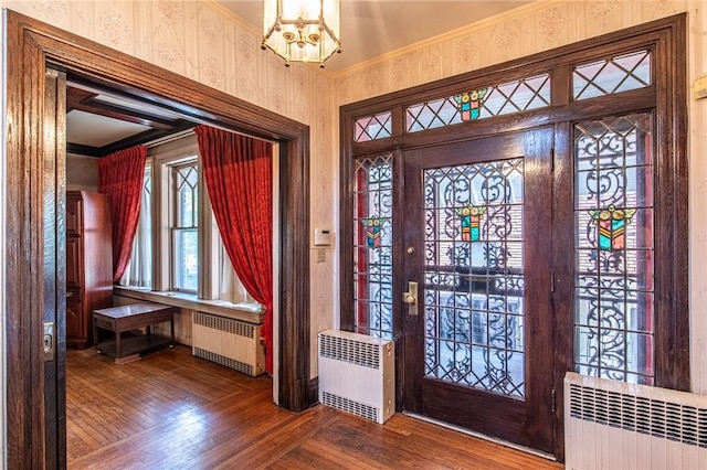 foyer entrance featuring hardwood / wood-style floors, radiator, and ornamental molding