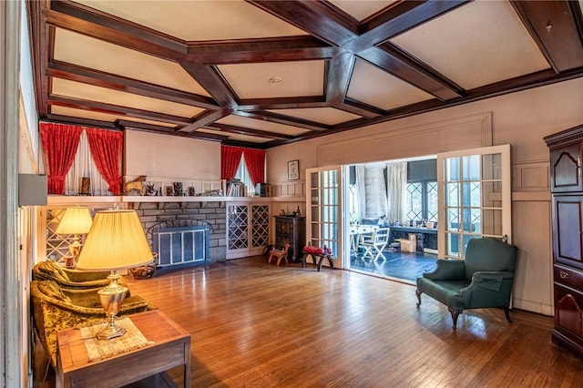 living room featuring a fireplace, hardwood / wood-style floors, beamed ceiling, and coffered ceiling