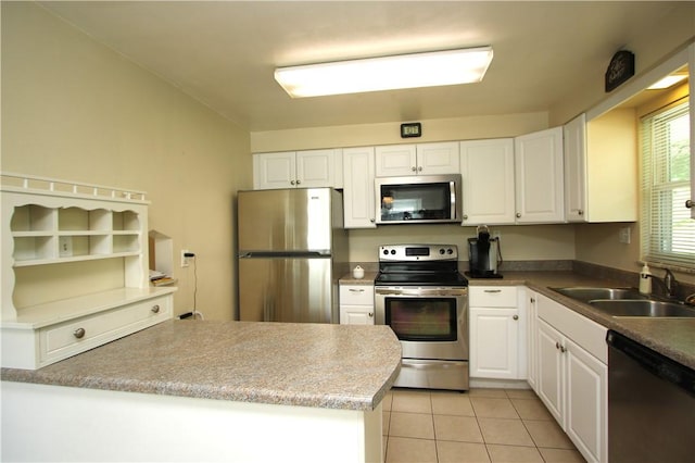 kitchen with stainless steel appliances, sink, white cabinetry, light tile patterned floors, and kitchen peninsula