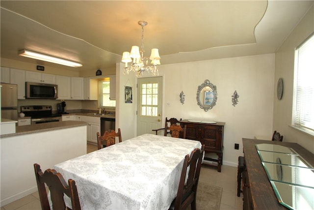 dining room with a healthy amount of sunlight, a notable chandelier, and light tile patterned floors