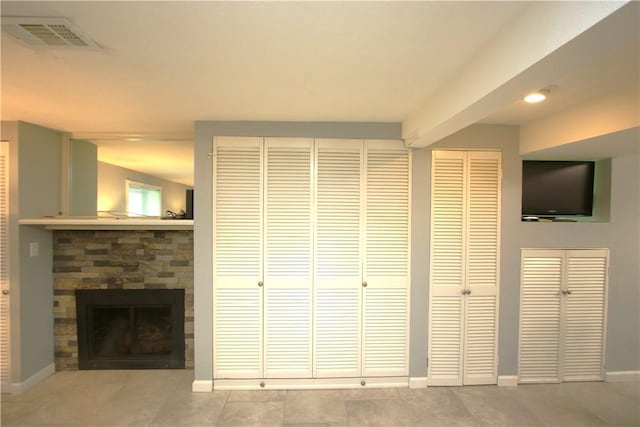 unfurnished living room featuring light tile patterned flooring and a fireplace