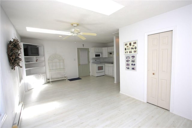 unfurnished living room featuring a baseboard heating unit, ceiling fan, and light hardwood / wood-style floors