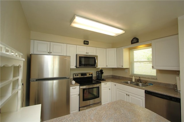 kitchen featuring stainless steel appliances, white cabinets, and sink