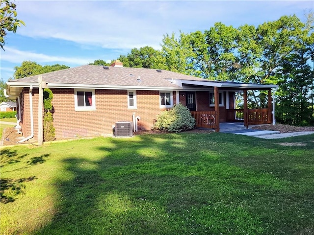 back of house with cooling unit and a yard