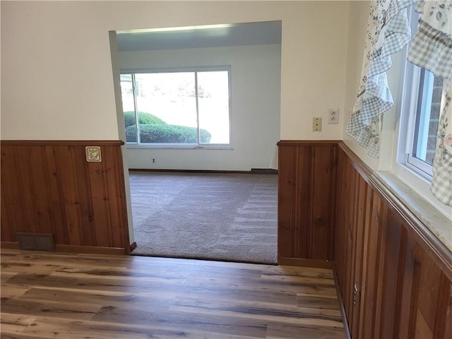 empty room featuring dark hardwood / wood-style flooring and wood walls