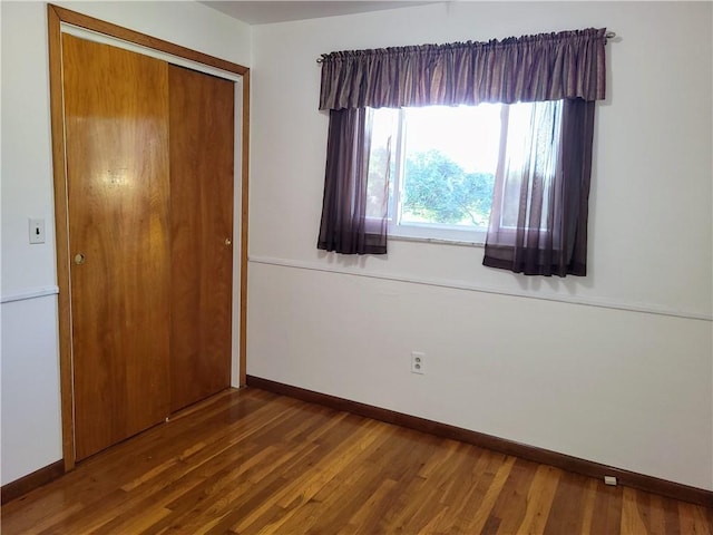 unfurnished bedroom with hardwood / wood-style flooring and a closet