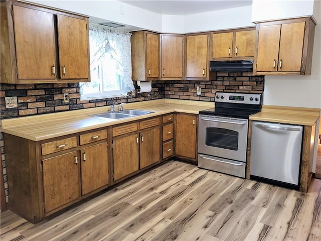 kitchen with stainless steel appliances, sink, and light hardwood / wood-style floors