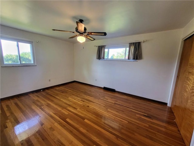 unfurnished room featuring ceiling fan, wood-type flooring, and plenty of natural light