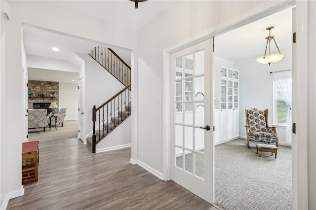 interior space featuring wood-type flooring, french doors, and brick wall