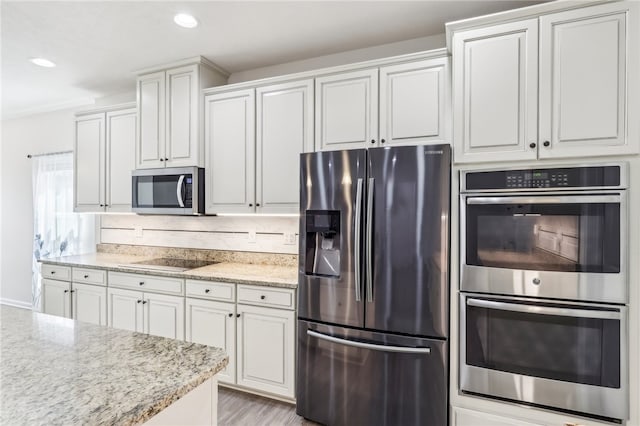 kitchen featuring white cabinetry, stainless steel appliances, crown molding, light stone counters, and light hardwood / wood-style flooring