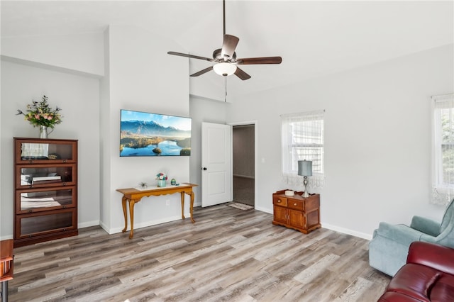 living room featuring hardwood / wood-style floors, high vaulted ceiling, and ceiling fan