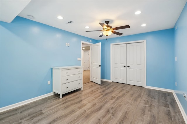 unfurnished bedroom featuring a closet, light wood-type flooring, and ceiling fan