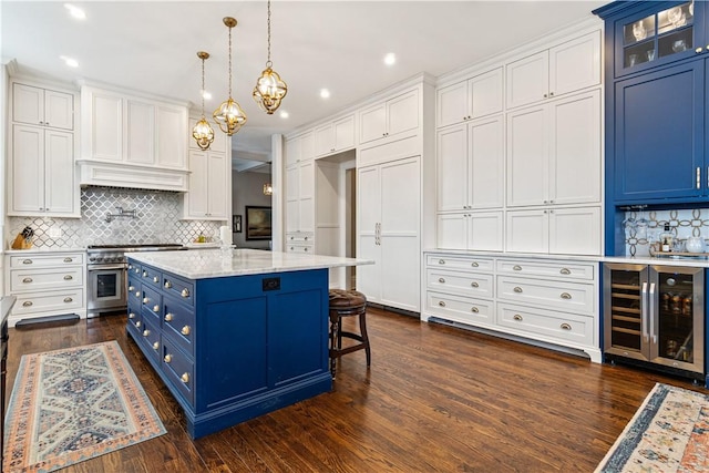 kitchen with beverage cooler, dark wood-type flooring, stainless steel range, hanging light fixtures, and blue cabinets